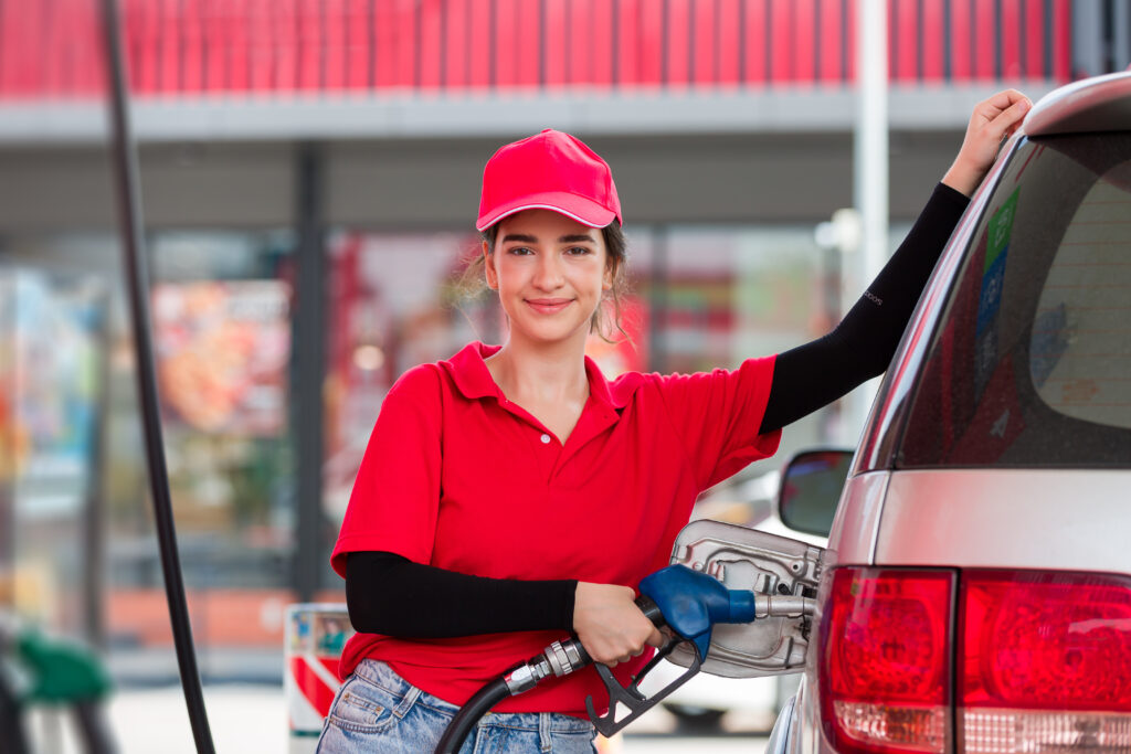 Attendant refueling car at a gas station